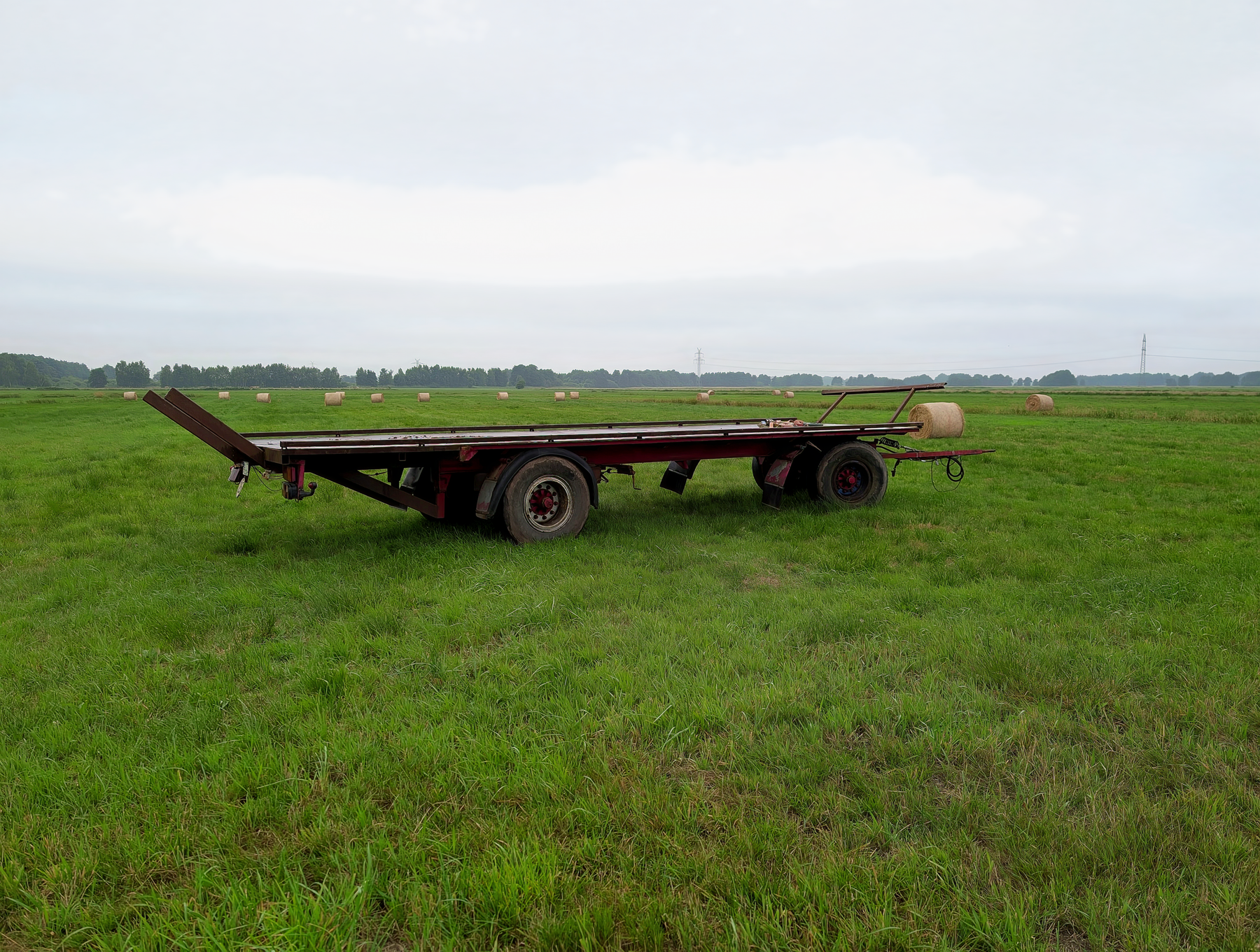 Flatbed equipment trailer parked in an open farm field